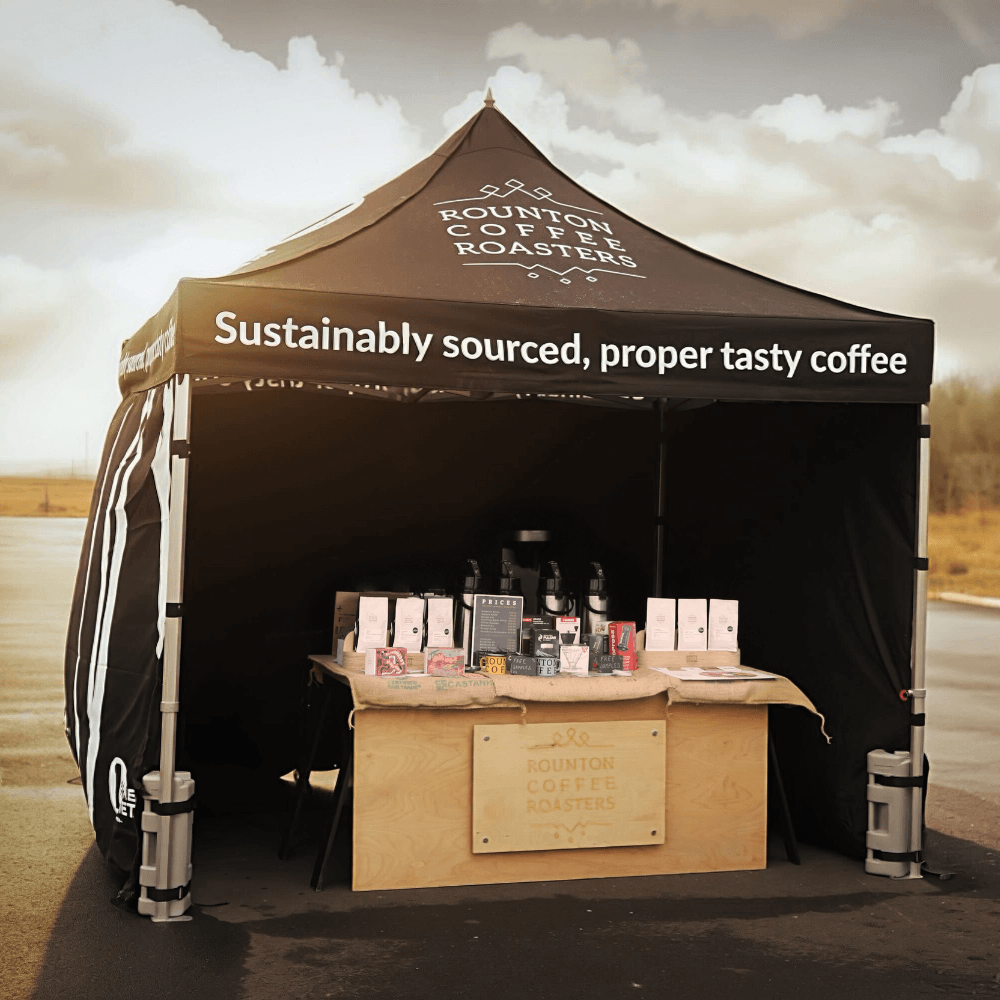 Rounton Coffee Roasters stall under a tent with coffee bags on a table