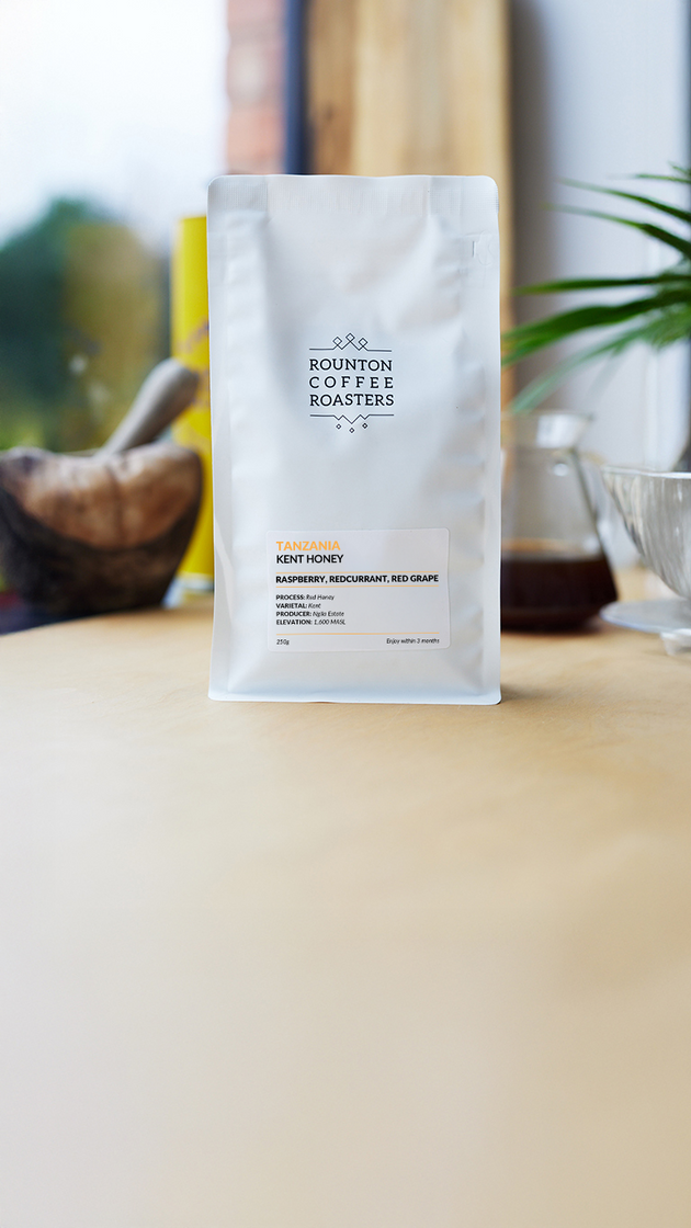 White coffee bag with Rounton Coffee Roasters logo on a wooden surface