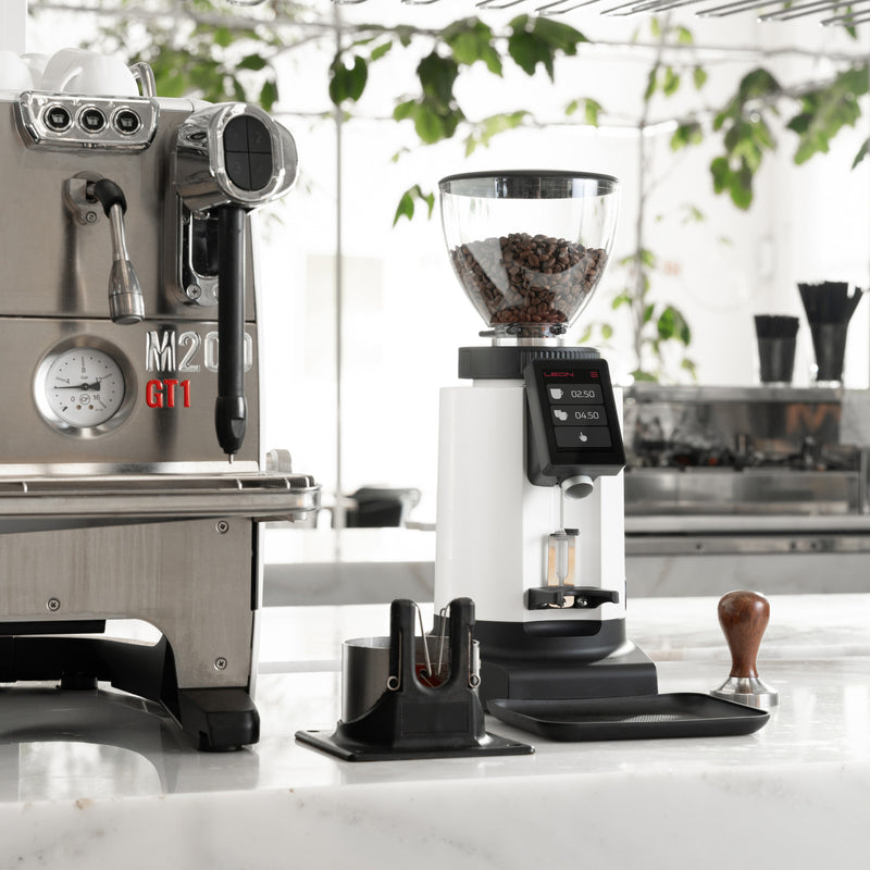 Leon 600 coffee grinder with beans, dosing device, and espresso machine on counter