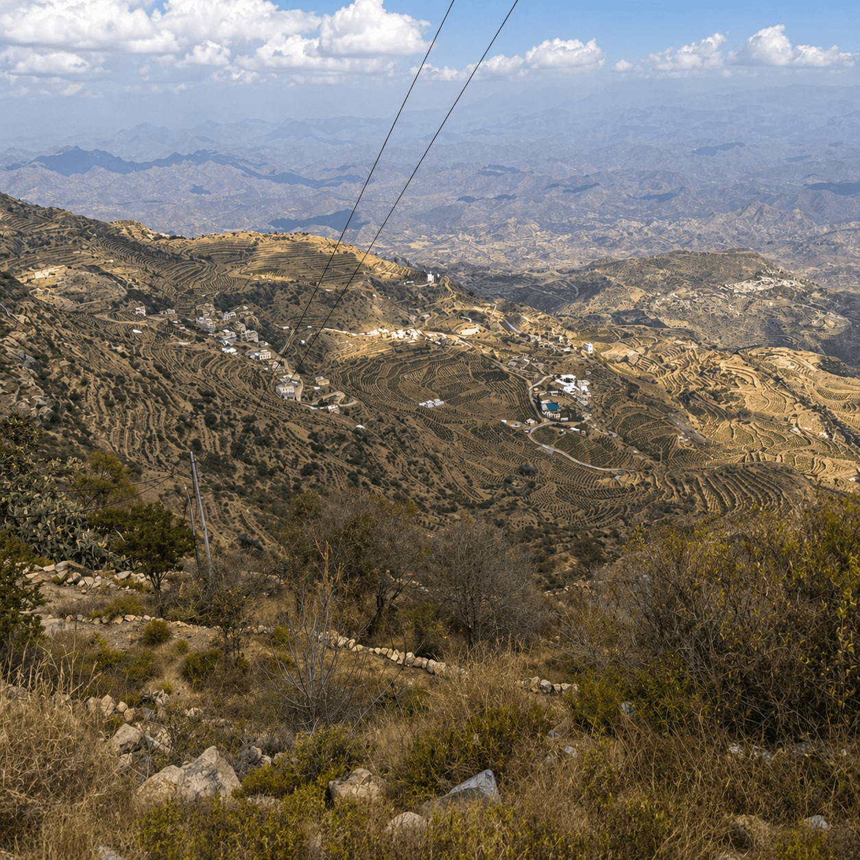 Scenic view of mountainous landscape with power lines and buildings.